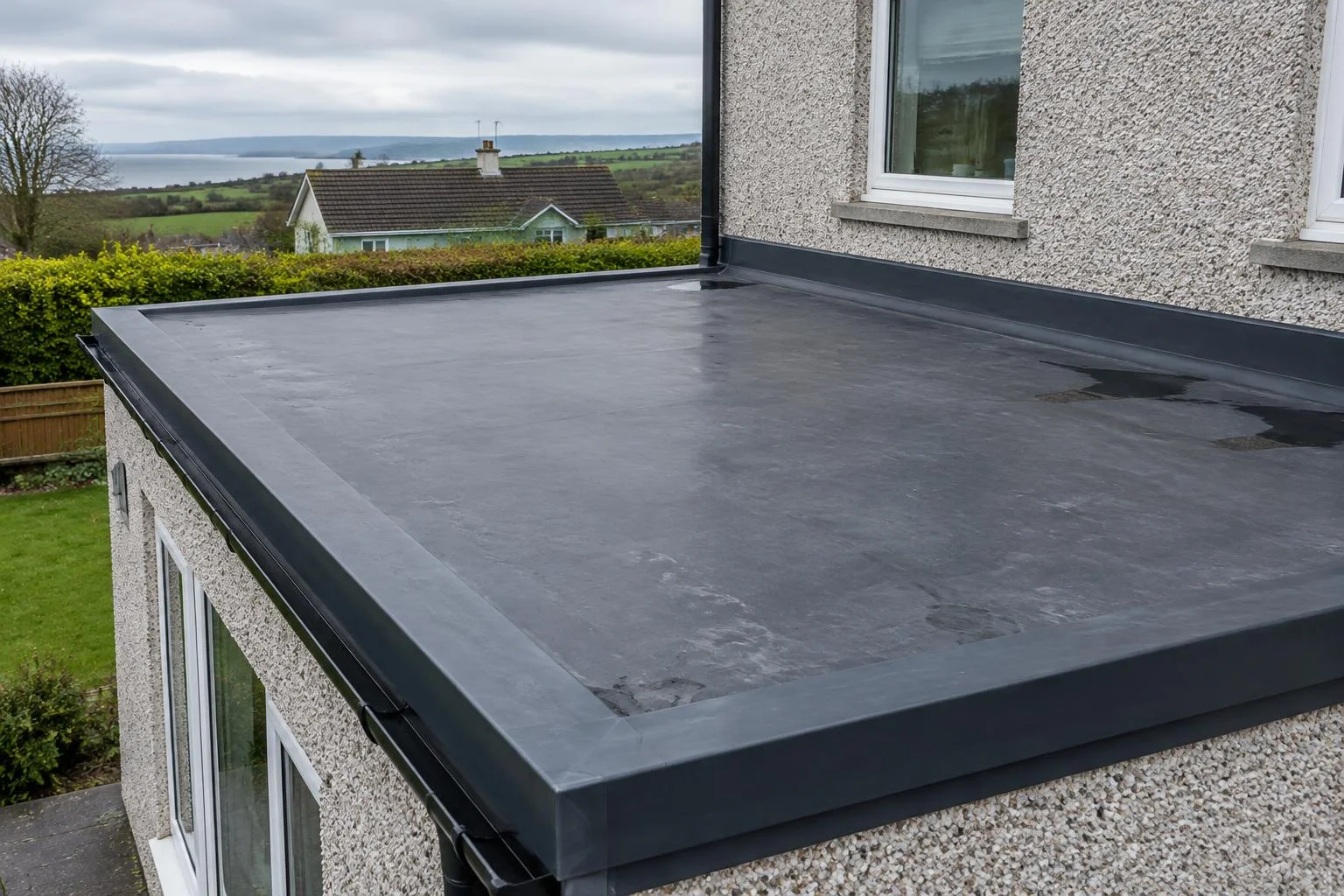 Flat membrane roof and perimeter flashing on an Irish house extension